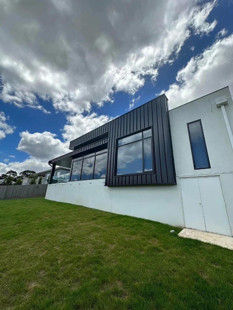 Dark vertical standing seam architectural cladding on a modern home